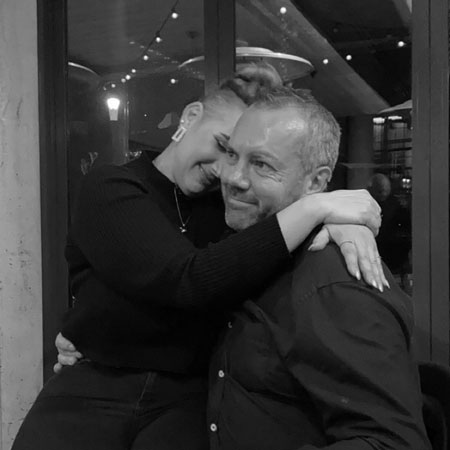 A black and white photo of Aaron and Tori embracing in a warm hug.